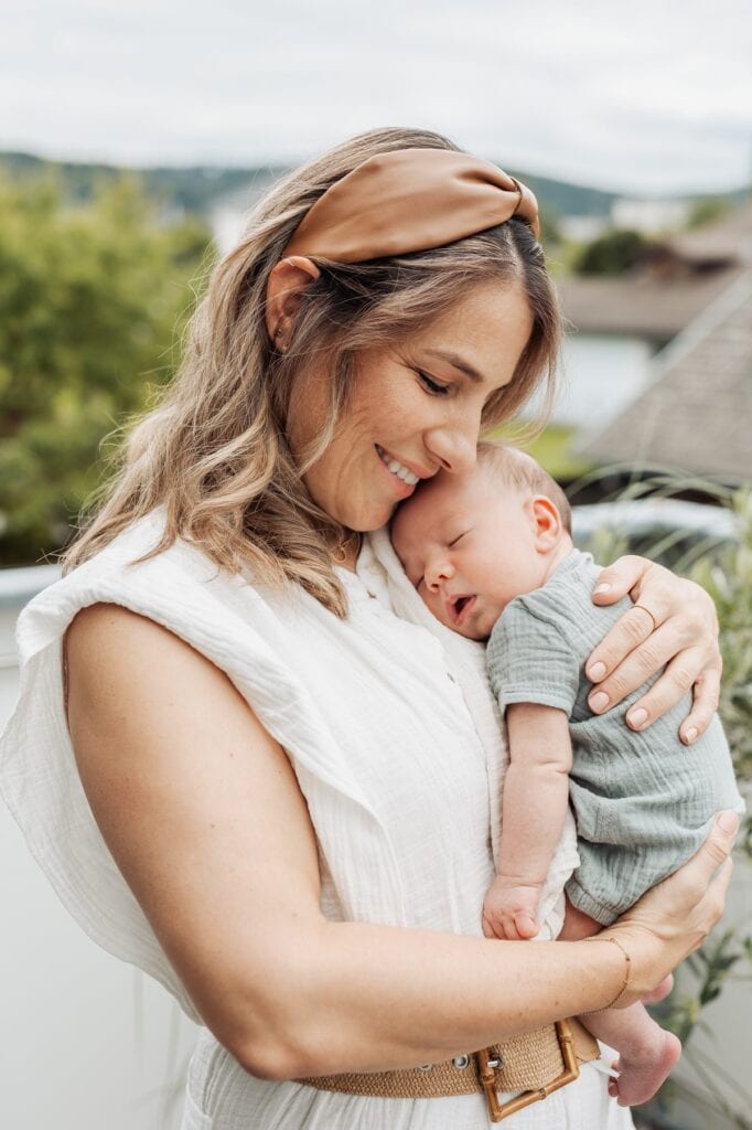Eine Frau hält ein Baby auf einem Dach.