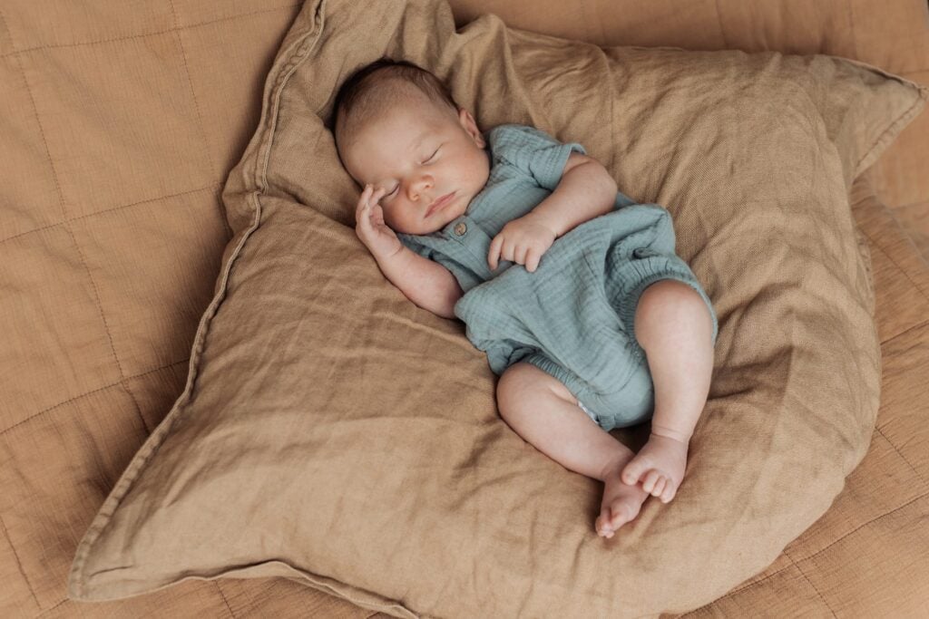 Ein Baby, das auf einem braunen Kissen schläft.