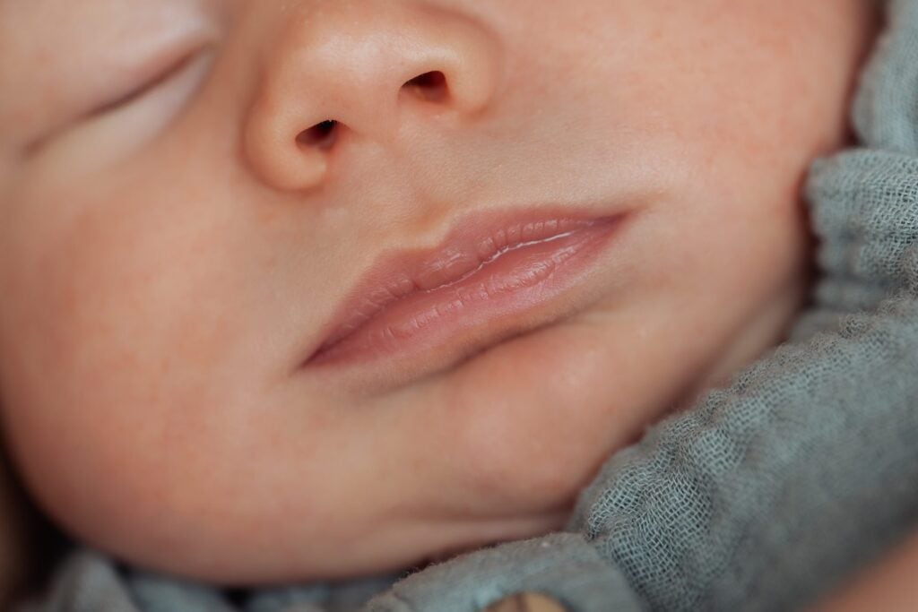Eine Nahaufnahme eines Babys, das mit geschlossenen Augen schläft.