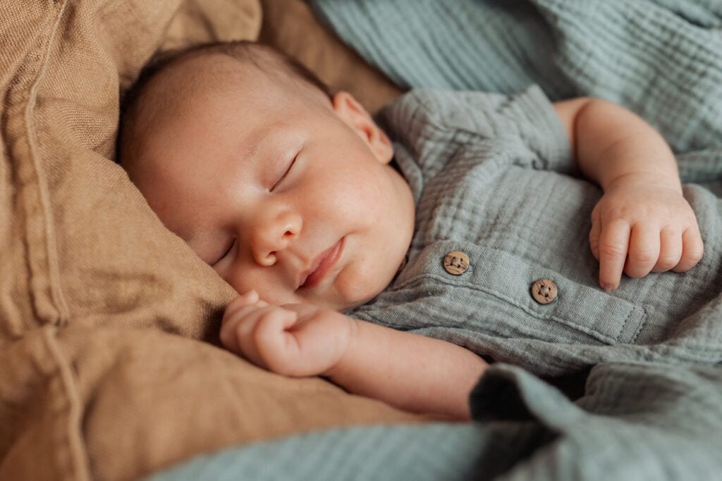 Ein Baby, das in einer blauen Decke schläft.