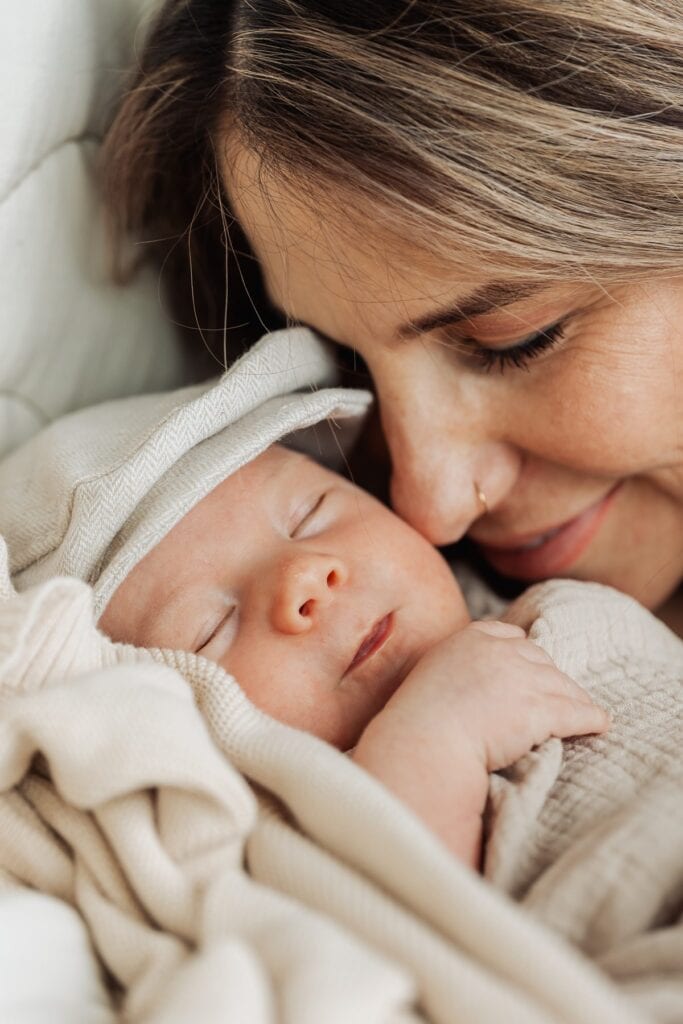 Eine Frau hält ein neugeborenes Baby im Arm.